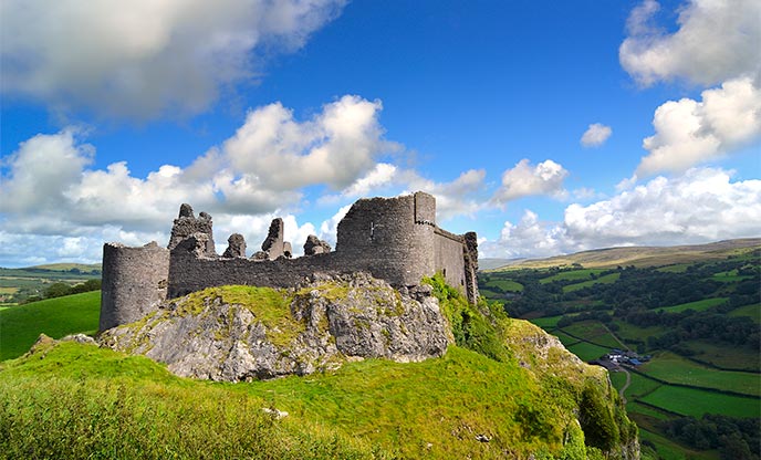 Looking up at a Carreg Cennen Castle up on a hill 