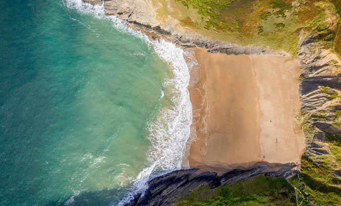 Arial view of a sandy cove with turquoise waters in Ceredigion 