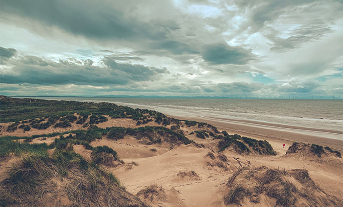 Looking out across the sand dunes, beach and ocean at Formby beach in Cheshire