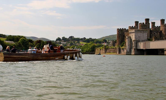 A group of peope on a boat enjoying a Conwy sightseeing cruise
