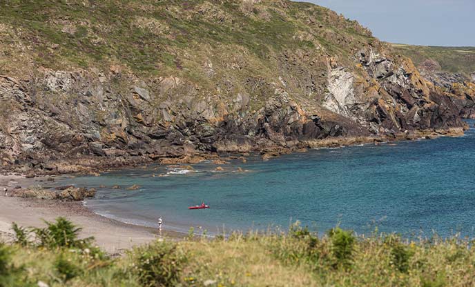 A view of Kennack Beach on the Lizard with a kayak on the shore