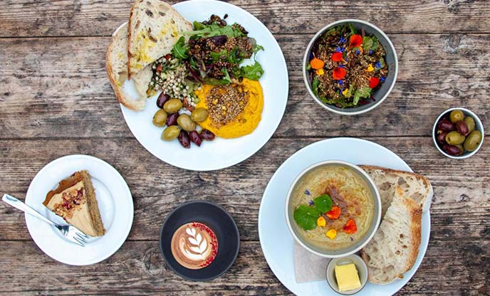 A table full of coffees and various vegan dishes at Potager Garden Cafe