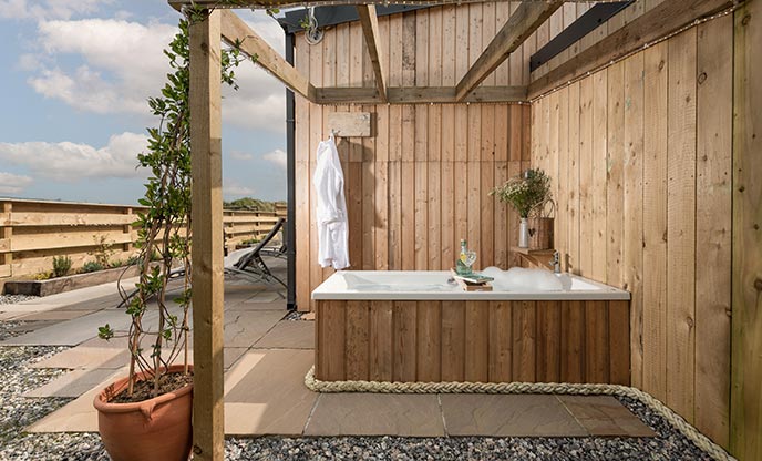 Cabin with a bubble-filled outdoor bathtub in Cornwall