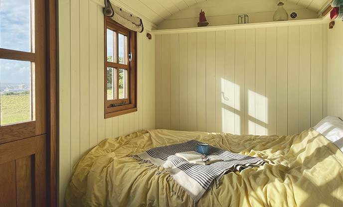 The double bed in Tamar Hut with sunshine pouring in