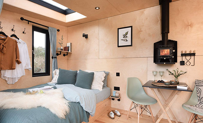 The interior of The Bird Box in Cornwall, with the stargazing window visible above the bed.