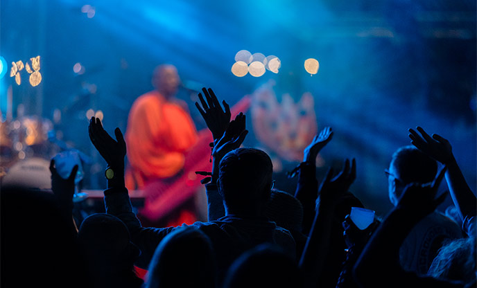 A crowd dances as a band performs at night at a festival in Cornwall