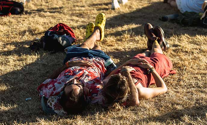 Two people lying in the grass enjoying a music festival in Cornwall