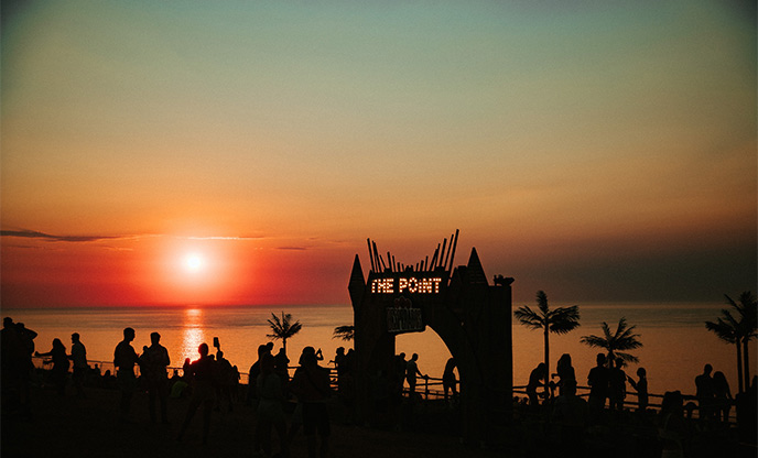 Orange sunset over the sea and The Point stage at Boardmasters Festival