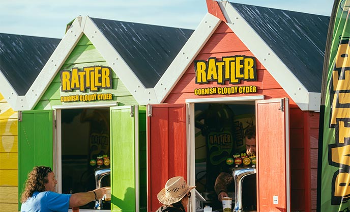 Colourful huts selling cider at Rattler Fest in Cornwall