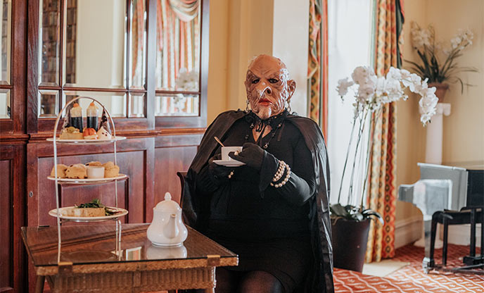 Witch actor having afternoon tea at The Headland Hotel in Newquay, Cornwall