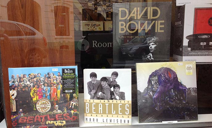 Looking through a shop window at records by The Beatles and David Bowie