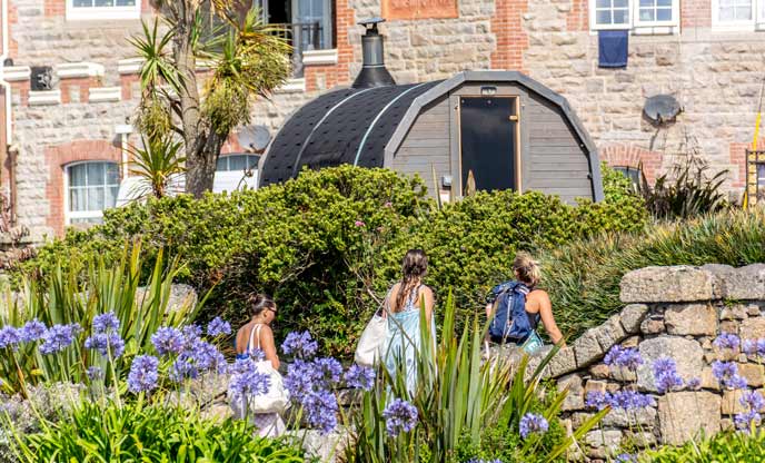 Barrel sauna nestled within St Anthony Gardens, Penzance