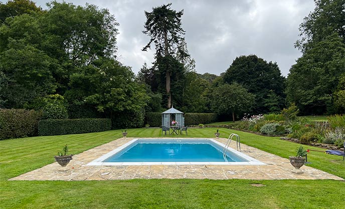 Swimming pool in a lush green English garden