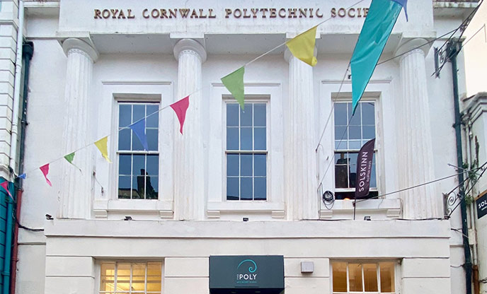 White exterior and colourful bunting outside The Poly in Falmouth