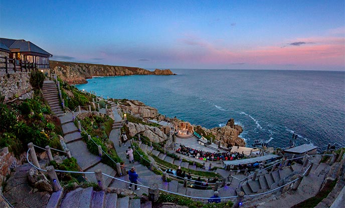 Sunsetting over the sea and clifftop theatre in Cornwall