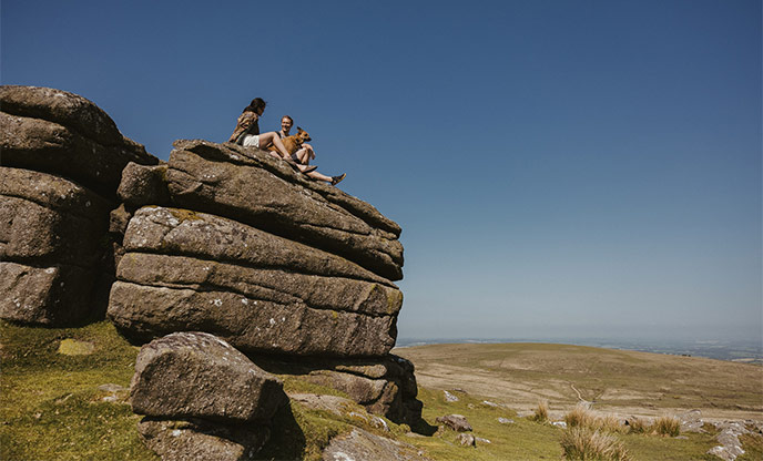 People sat atop Haytor Rocks in Dartmoor