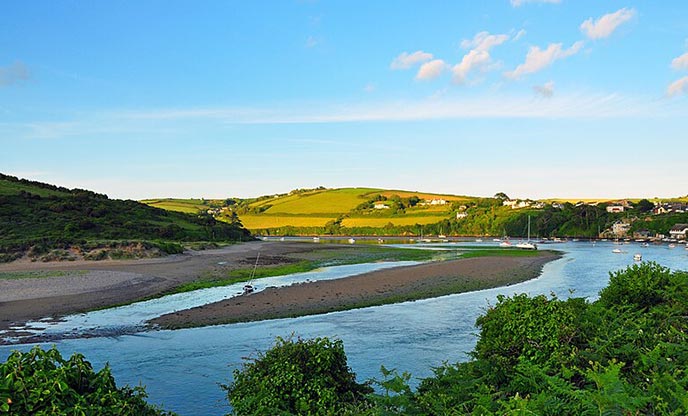 A view of the River Avon as it winds through a valley with green hills in the distance