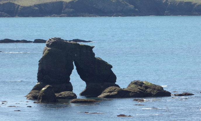 A rock arch emerging from the sea