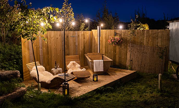 Twinkling fairy lights over magical outdoor bathtubs