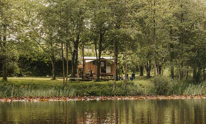 A dreamy shepherd's hut overlooking a peaceful lake.