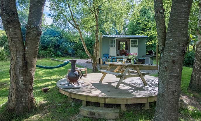 Sweet shepherd's hut nestled amongst woodland with decking area and firepit