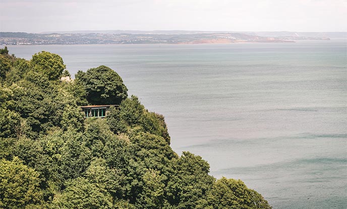 Secluded clifftop cabin nestled within the trees overlooking the sea in Devon
