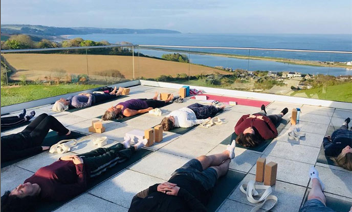 A yoga glass on a raised balcony overlooking fields and the sea in Devon