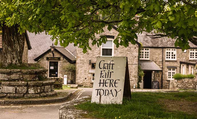 A craft fair sign in front of a cosy pub in Widecombe-in-the-Moor