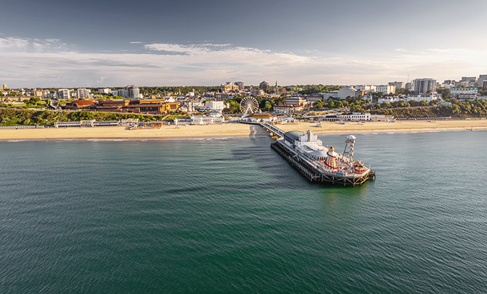 An aerial view of Bournemouth and its golden-sand beach under blue skies