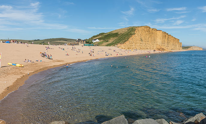 Looking down the beach at West Bay at the iconic golden sandstone cliffs