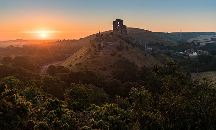 Looking up the hill at the ruins of Corfe Castle in Dorset at sunset