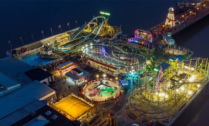 Drone shot overlooking the vibrant Clacton Pier at night