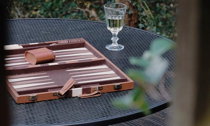 A wooden backgammon game on an outdoor table