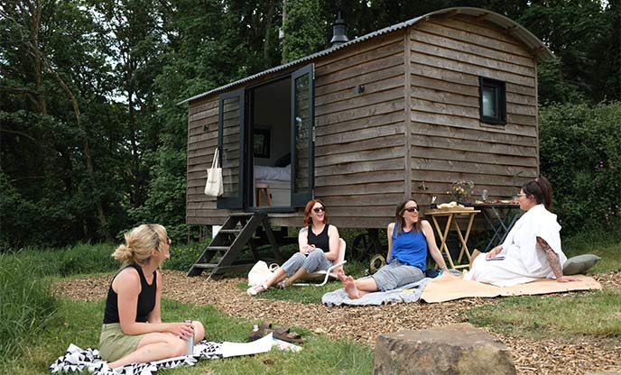 A group journaling session beside a shepherd's hut