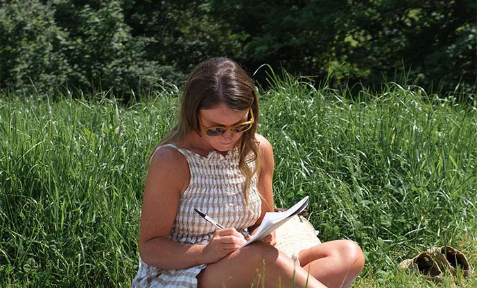 Journaling outside amongst lush green grass