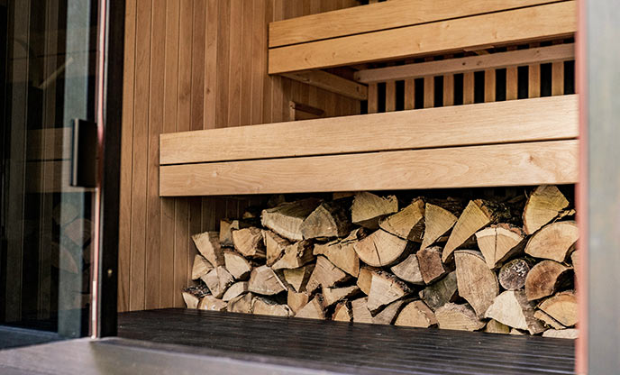 Wood stacked in the entrance of a sauna 