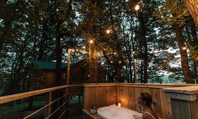 A person relaxing in a bath under the trees