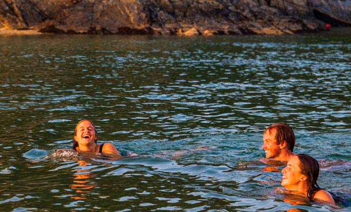 Friends wild swimming at sunset in Cornwall