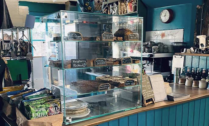The teal counter at Rocket Kitchen Café with a display of cakes