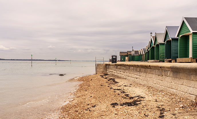 Beach huts overlooking the sea on Gurnard Beach, Isle of Wight