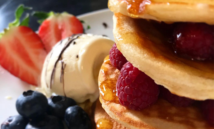 Pancakes with fruit and syrup at The Mill Café