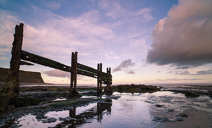 The beach, sea and sky are a stunning purple at sunset at St Audries Bay in Somerset