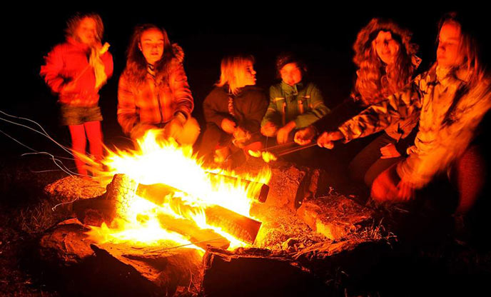 Family friendly glamping - toasting marshmallows on a fire
