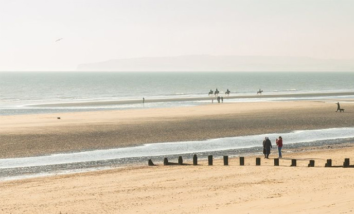 Wide stretch of golden sand and wooden sand groyne at Camber Sands