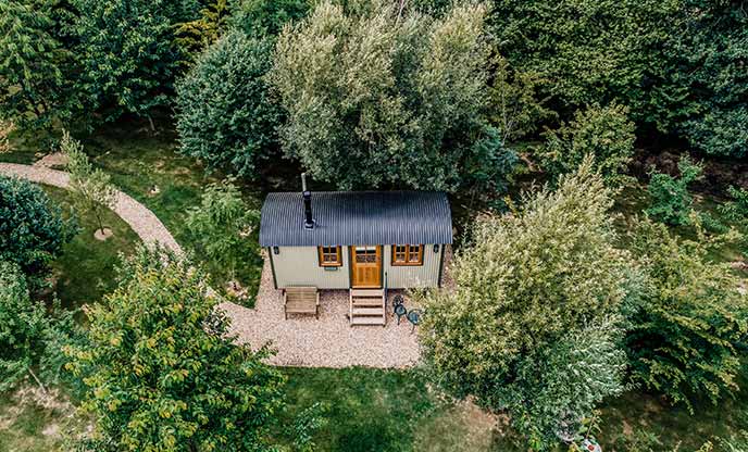 Shepherd's hut nestled amongst the trees in the east Sussex countryside