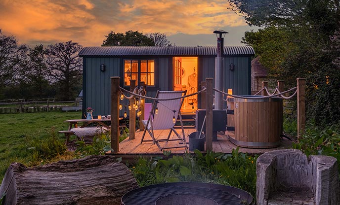 Dusk settles over magical shepherd's hut in  west Sussex with a hot tub