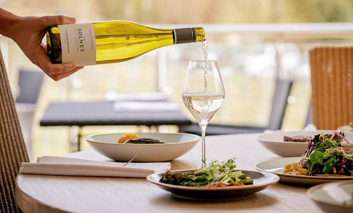 A glass of Bolney white wine being served alongside lunchtime plates