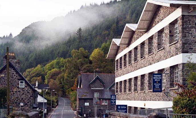Exterior of traditional woollen mill nestled within the mountains in Wales