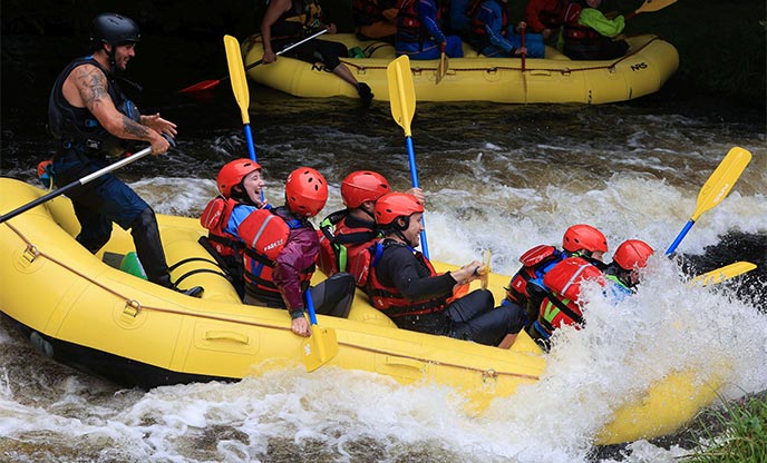 A group of people white water rafting in Wales 